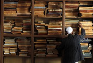 Мужчина берет экземпляр Корана в мечети в старом городе (Сана, Йемен / Sana’a, Yemen)